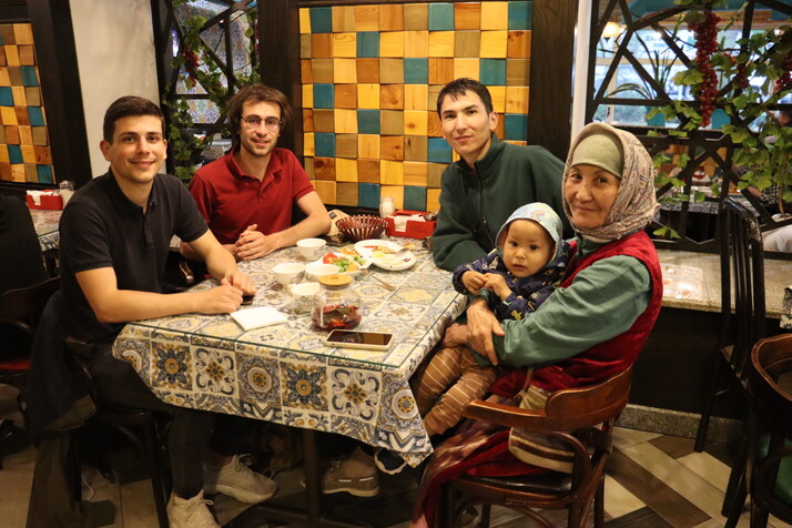 Photographie de Baptiste et Tanguy, co-fondateurs de Kashgar Artisananat, attablés avec une artisane partenaire au Kirghizistan, ainsi que son fils et son petit-fils